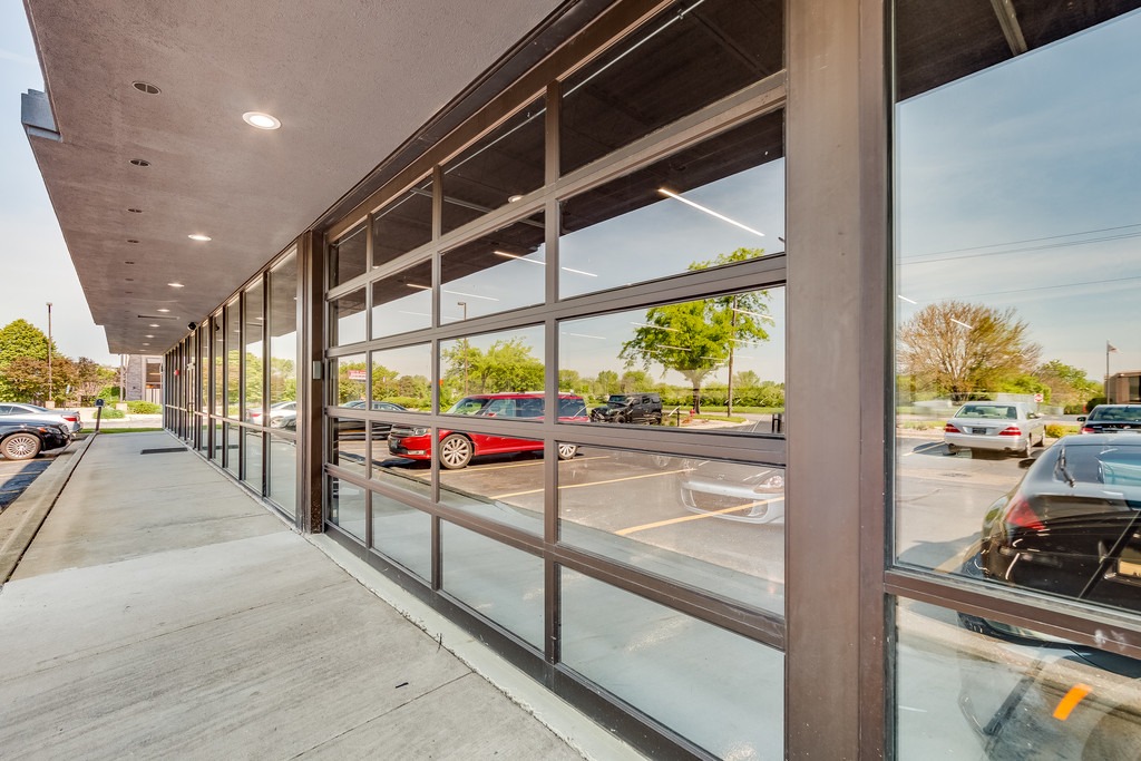 Tereza AlumaView aluminum full view sectional door installed on modern commercial building showing natural light and glass panel detail