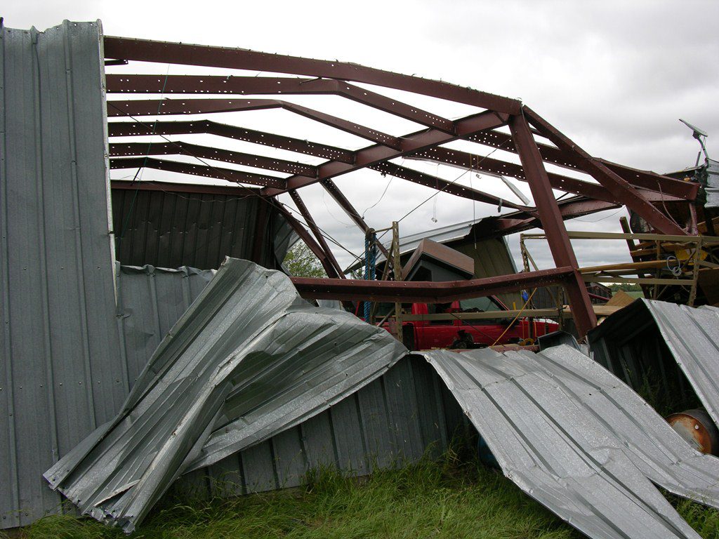 Butler metal building field repair crew replacing damaged roof panels or wall panels on a commercial warehouse or industrial facility using OEM Butler compatible materials