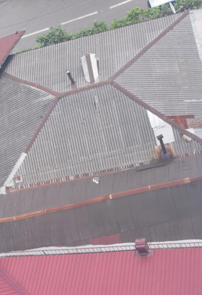 Aging through-fastened metal roof on commercial industrial building showing fastener fatigue and weather deterioration before Butler re-roof replacement